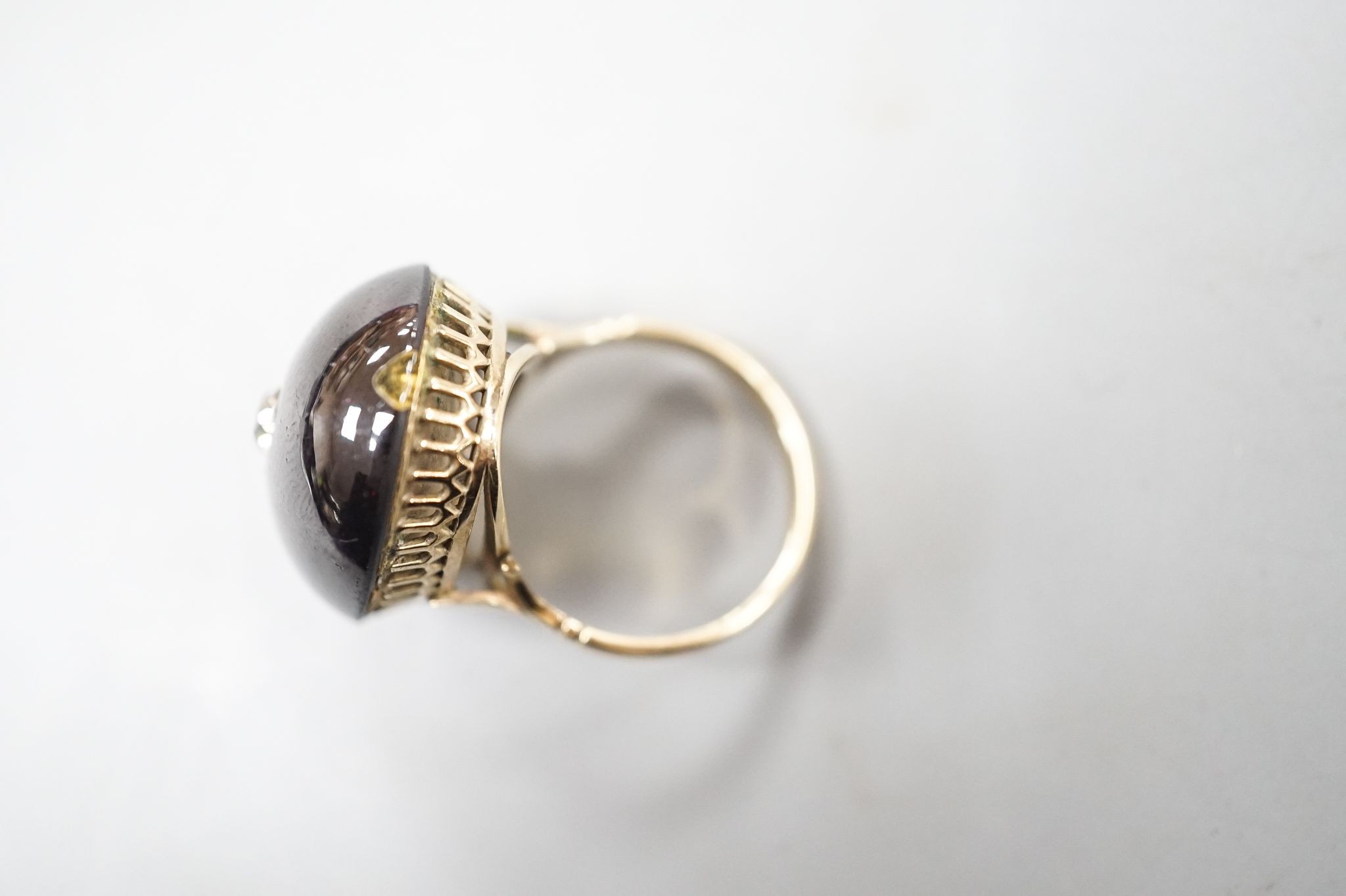 A yellow metal, foil backed cabochon garnet and diamond set oval dress ring, size P/Q, gross 11.1 grams, (a.f.).